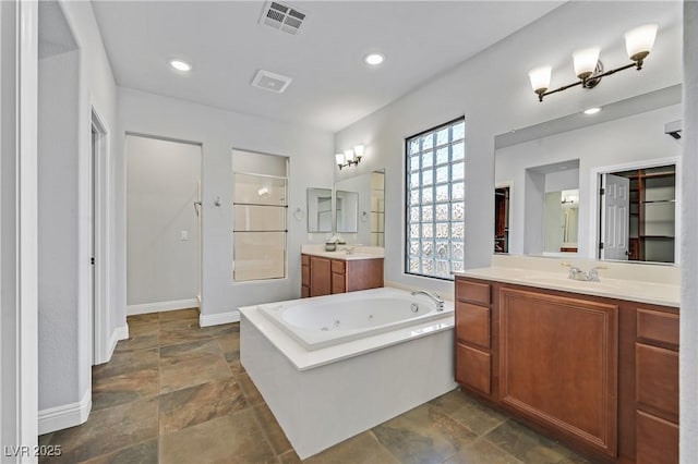 9008 Sawhill Pond St, Las Vegas, NV 89131 - bathroom with stone finish flooring, a whirlpool tub, two vanities, baseboards, and walk in shower