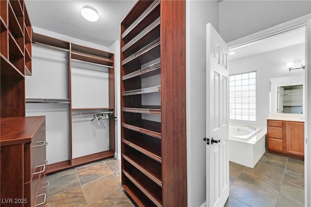 9008 Sawhill Pond St, Las Vegas, NV 89131 - spacious closet featuring stone finish floors