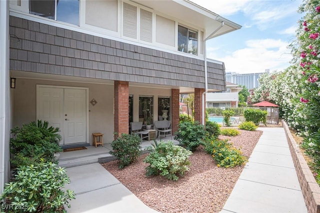 794 Oakmont Ave Unit 106, Las Vegas, NV 89109 - entrance to property with stucco siding, covered porch, mansard roof, and brick siding
