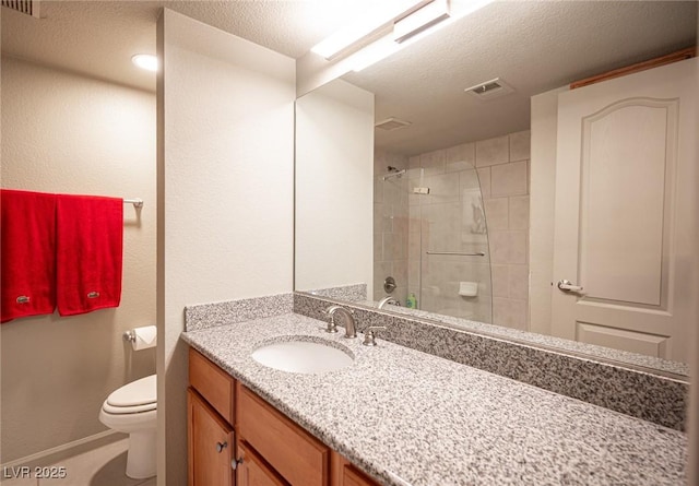 794 Oakmont Ave Unit 106, Las Vegas, NV 89109 - bathroom featuring toilet, vanity, a textured ceiling, tiled shower, and baseboards