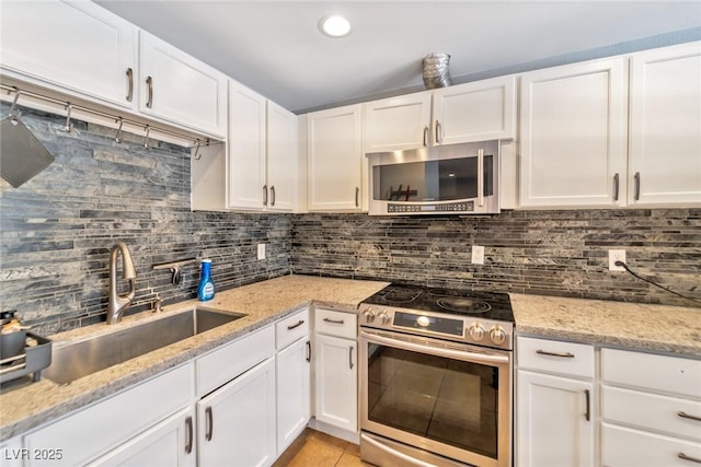 2708 Beaver Creek Ct Unit 202, Las Vegas, NV 89117 - kitchen with appliances with stainless steel finishes, a sink, backsplash, and white cabinets