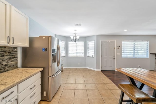 2708 Beaver Creek Ct Unit 202, Las Vegas, NV 89117 - kitchen with stainless steel fridge, a chandelier, healthy amount of natural light, white cabinets, and recessed lighting