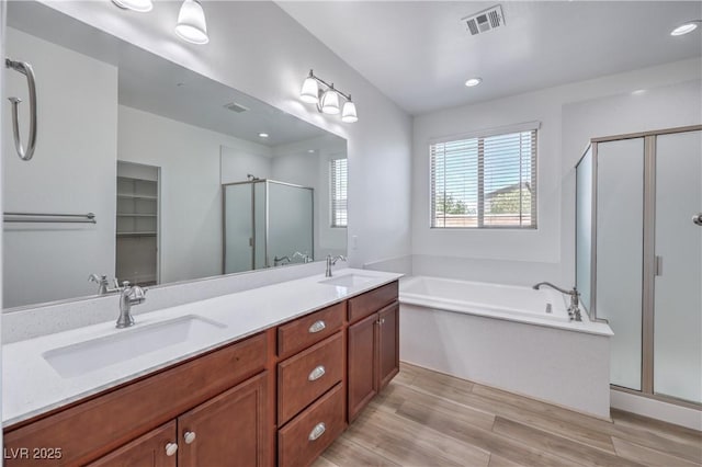 508 Cadence View Way, Henderson, NV 89011 - bathroom featuring a stall shower, a bath, wood finished floors, double vanity, and recessed lighting