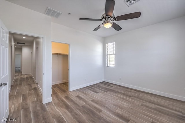 508 Cadence View Way, Henderson, NV 89011 - unfurnished bedroom with wood finished floors, baseboards, a walk in closet, a closet, and a ceiling fan