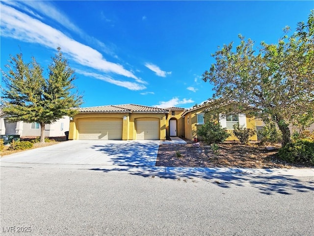 3829 N Mayfield Ranch Rd, Pahrump, NV 89060 - view of front of home featuring an attached garage, stucco siding, a tile roof, and concrete driveway
