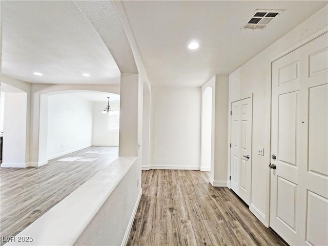 3829 N Mayfield Ranch Rd, Pahrump, NV 89060 - hallway featuring arched walkways, wood finished floors, recessed lighting, and baseboards