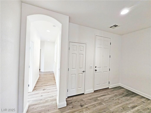 3829 N Mayfield Ranch Rd, Pahrump, NV 89060 - corridor featuring light wood finished floors, baseboards, recessed lighting, and arched walkways