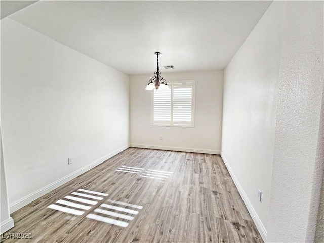 3829 N Mayfield Ranch Rd, Pahrump, NV 89060 - unfurnished dining area featuring wood finished floors, a chandelier, and baseboards