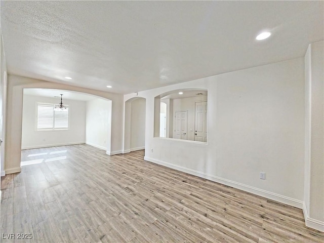 3829 N Mayfield Ranch Rd, Pahrump, NV 89060 - unfurnished room with wood finished floors, recessed lighting, arched walkways, and baseboards