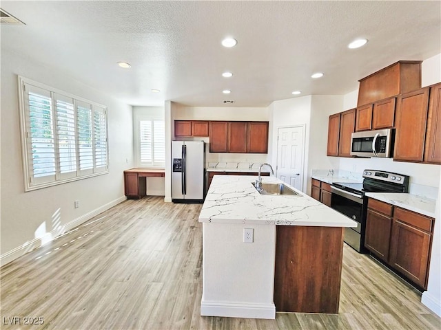 3829 N Mayfield Ranch Rd, Pahrump, NV 89060 - kitchen featuring appliances with stainless steel finishes, a sink, light wood-style floors, a kitchen island with sink, and recessed lighting