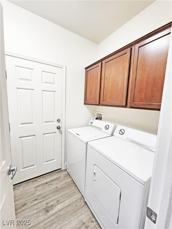 3829 N Mayfield Ranch Rd, Pahrump, NV 89060 - laundry area with separate washer and dryer, light wood-type flooring, and cabinet space