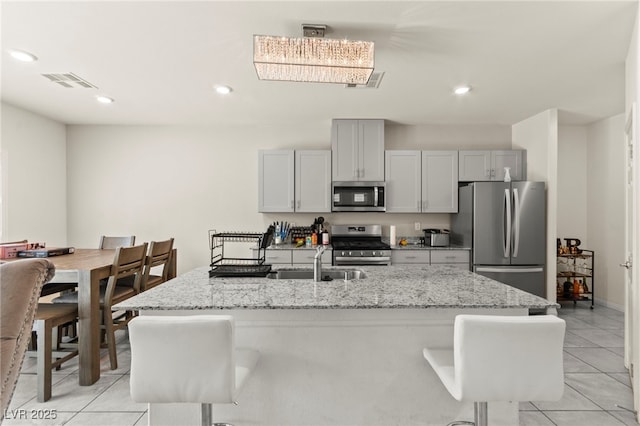 9161 Rolling Sky Dr, Las Vegas, NV 89178 - kitchen featuring appliances with stainless steel finishes, a sink, light tile patterned flooring, light stone countertops, and recessed lighting