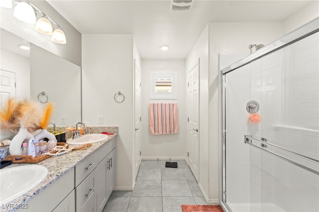 9161 Rolling Sky Dr, Las Vegas, NV 89178 - bathroom featuring tile patterned floors, double vanity, a stall shower, and baseboards