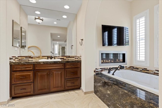 300 N Royal Ascot Dr, Las Vegas, NV 89144 - bathroom with plenty of natural light, vanity, a bath, decorative backsplash, and recessed lighting