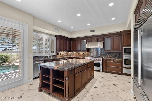 300 N Royal Ascot Dr, Las Vegas, NV 89144 - kitchen with under cabinet range hood, built in appliances, tasteful backsplash, open shelves, and light tile patterned floors