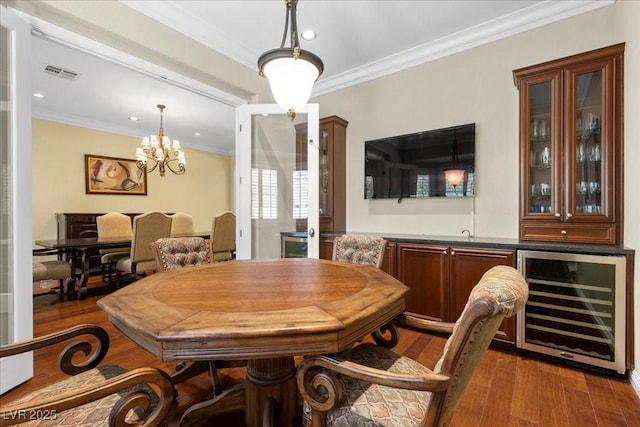 300 N Royal Ascot Dr, Las Vegas, NV 89144 - dining space featuring beverage cooler, ornamental molding, wood finished floors, a chandelier, and bar