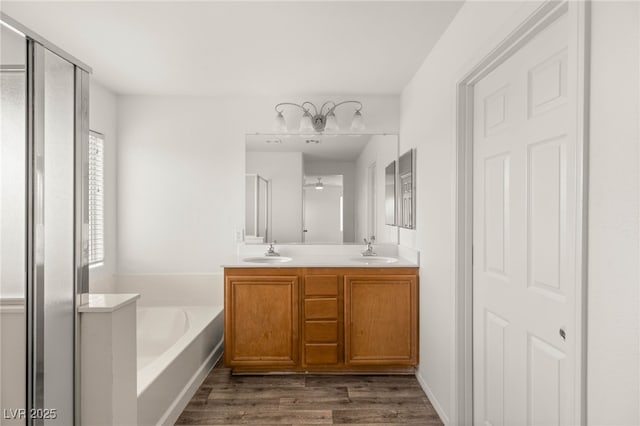 6480 Chebec St, North Las Vegas, NV 89084 - bathroom featuring a garden tub, a stall shower, double vanity, and wood finished floors