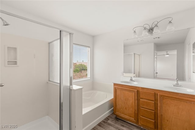 6480 Chebec St, North Las Vegas, NV 89084 - full bathroom featuring a shower stall, a bath, double vanity, and wood finished floors