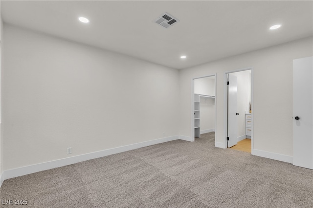 3151 Soaring Gulls Dr Unit 1179, Las Vegas, NV 89128 - unfurnished bedroom with light carpet, recessed lighting, baseboards, a spacious closet, and connected bathroom