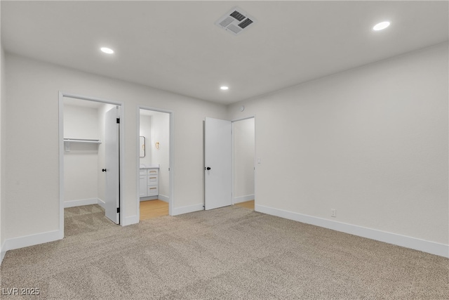 3151 Soaring Gulls Dr Unit 1179, Las Vegas, NV 89128 - unfurnished bedroom with light colored carpet, a spacious closet, baseboards, recessed lighting, and ensuite bath