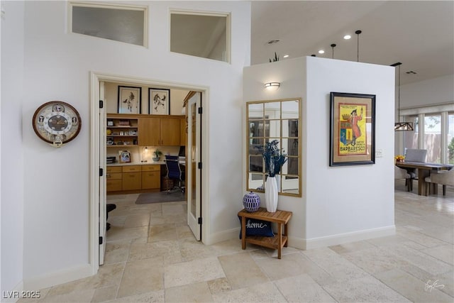 522 Via Ventana Dr, Mesquite, NV 89027 - hallway featuring stone tile floors, baseboards, a desk, a high ceiling, and recessed lighting