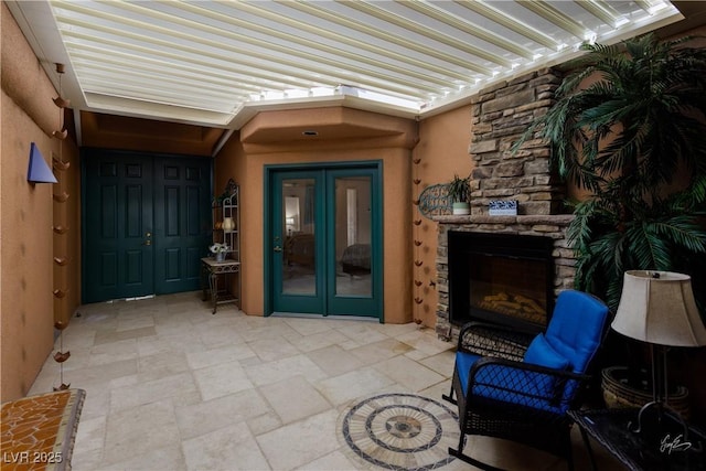 522 Via Ventana Dr, Mesquite, NV 89027 - view of exterior entry featuring an outdoor stone fireplace, french doors, stucco siding, stone siding, and a patio