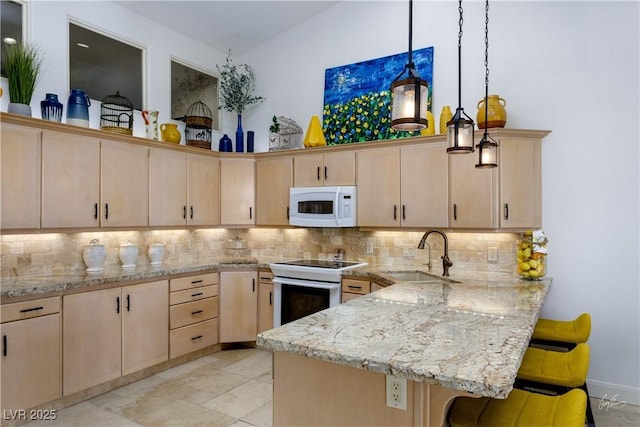 522 Via Ventana Dr, Mesquite, NV 89027 - kitchen featuring a sink, white appliances, light brown cabinetry, a peninsula, and a breakfast bar area