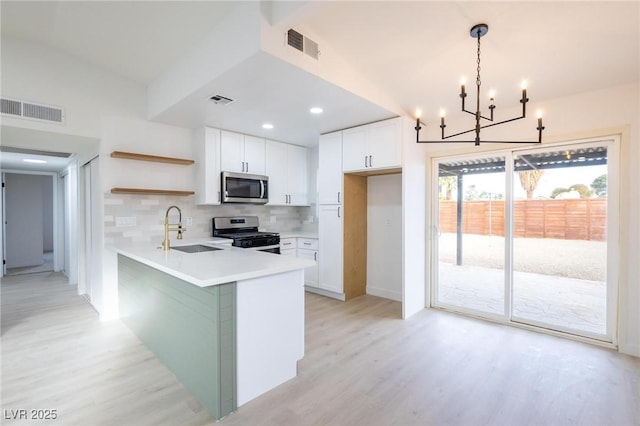 6170 W University Ave, Las Vegas, NV 89103 - kitchen featuring stainless steel appliances, a sink, light wood-type flooring, open shelves, and recessed lighting