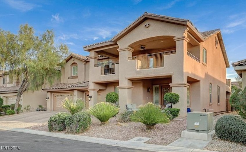 8093 Luna Sera Ave, Las Vegas, NV 89178 - mediterranean / spanish house with a balcony, stucco siding, a garage, and driveway