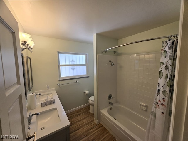 6284 Explorer Dr, Las Vegas, NV 89103 - bathroom featuring toilet, double vanity, wood finished floors, shower / tub combo, and baseboards