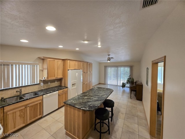 6284 Explorer Dr, Las Vegas, NV 89103 - kitchen with white appliances, a sink, a ceiling fan, a kitchen bar, and a center island