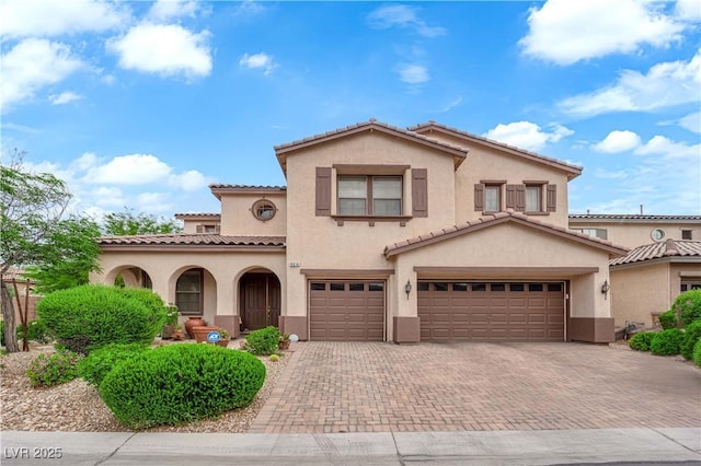 9614 Stonily Ln, Las Vegas, NV 89178 - mediterranean / spanish home featuring stucco siding, an attached garage, decorative driveway, and a tiled roof