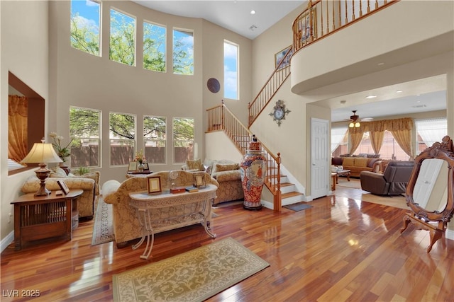 9614 Stonily Ln, Las Vegas, NV 89178 - living room featuring stairway, wood finished floors, a towering ceiling, a ceiling fan, and baseboards