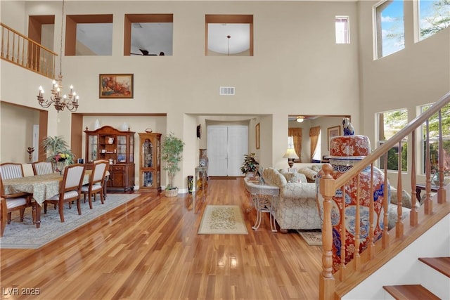 9614 Stonily Ln, Las Vegas, NV 89178 - living area featuring a towering ceiling, a chandelier, wood finished floors, plenty of natural light, and stairway
