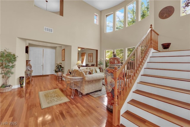 9614 Stonily Ln, Las Vegas, NV 89178 - living area with a high ceiling, stairs, wood finished floors, and baseboards