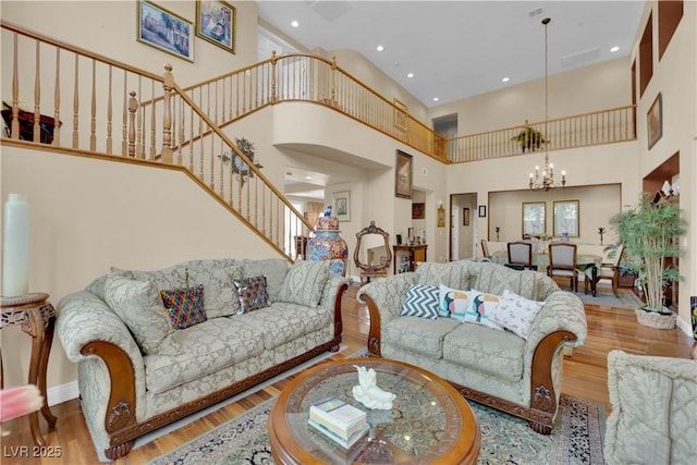 9614 Stonily Ln, Las Vegas, NV 89178 - living area featuring a chandelier, a high ceiling, wood finished floors, stairs, and baseboards