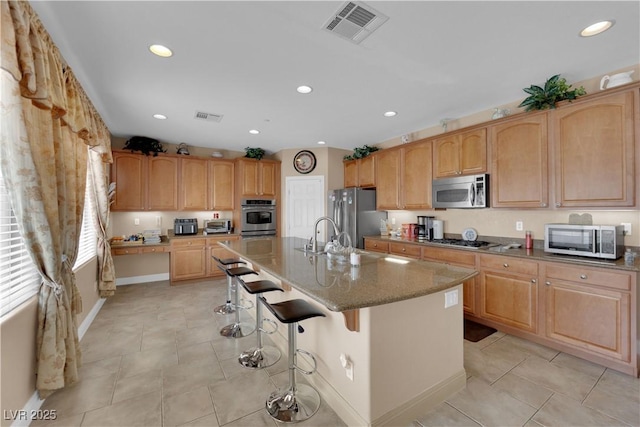 9614 Stonily Ln, Las Vegas, NV 89178 - kitchen with stainless steel appliances, a breakfast bar, recessed lighting, stone counters, and light tile patterned flooring