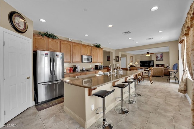 9614 Stonily Ln, Las Vegas, NV 89178 - kitchen with stainless steel appliances, ceiling fan, a sink, a kitchen breakfast bar, and open floor plan