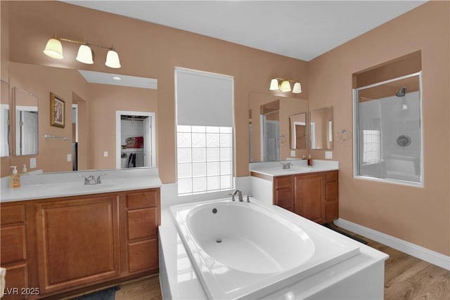 9614 Stonily Ln, Las Vegas, NV 89178 - full bath featuring a bath, a stall shower, two vanities, and wood finished floors
