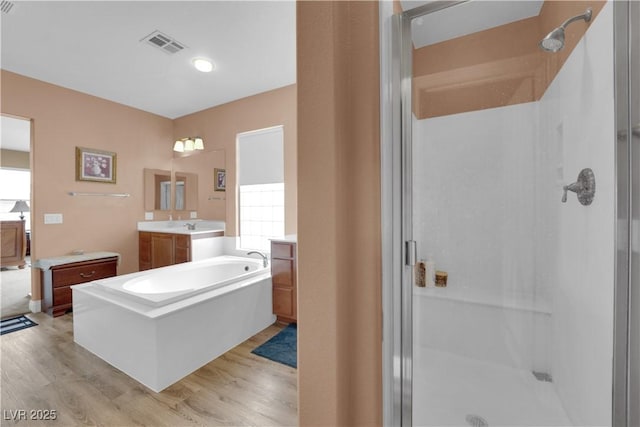 9614 Stonily Ln, Las Vegas, NV 89178 - bathroom with a shower stall, wood finished floors, two vanities, and a bath