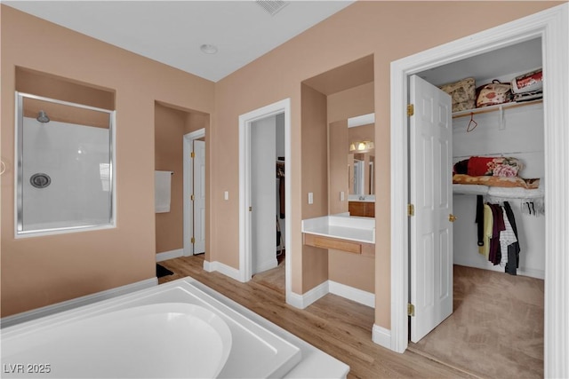 9614 Stonily Ln, Las Vegas, NV 89178 - bathroom with a spacious closet, wood finished floors, a tub to relax in, a shower, and vanity