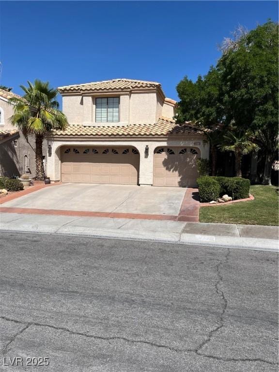 2320 Angelfire St, Las Vegas, NV 89128 - mediterranean / spanish home with concrete driveway, a tiled roof, stucco siding, an attached garage, and a garage