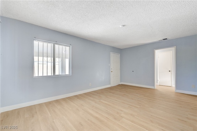 813 E Bartlett Ave, North Las Vegas, NV 89030 - empty room featuring a textured ceiling, light wood-type flooring, and baseboards