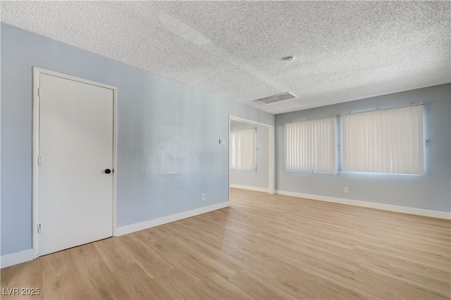 813 E Bartlett Ave, North Las Vegas, NV 89030 - empty room with wood finished floors, a textured ceiling, and baseboards
