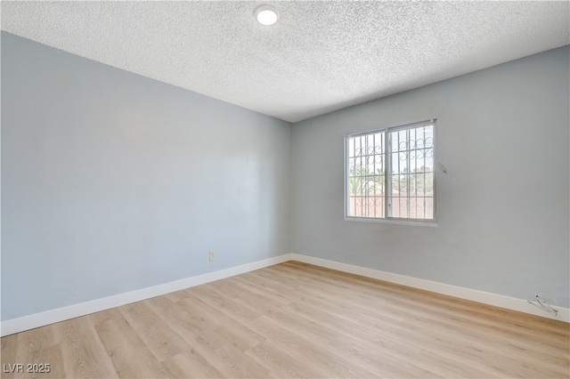 813 E Bartlett Ave, North Las Vegas, NV 89030 - spare room with light wood-style flooring, a textured ceiling, and baseboards