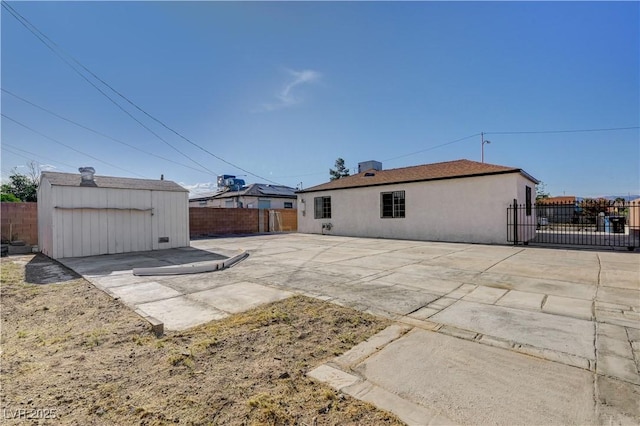 813 E Bartlett Ave, North Las Vegas, NV 89030 - rear view of property with a fenced backyard, a patio, a storage shed, and stucco siding