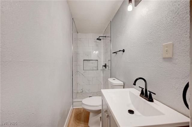 813 E Bartlett Ave, North Las Vegas, NV 89030 - full bath featuring a textured wall, wood finished floors, tiled shower, and vanity