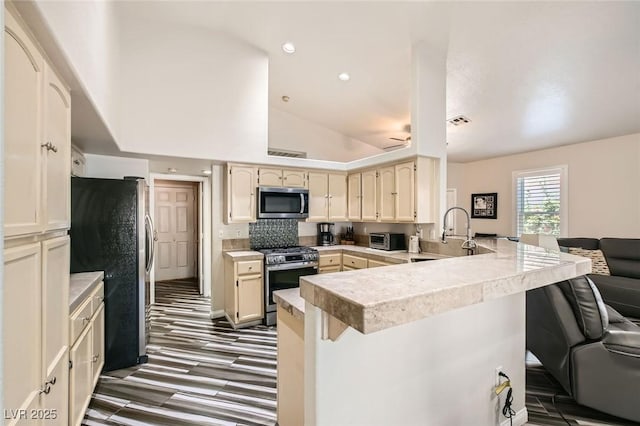 5489 Royal Vista Ln, Las Vegas, NV 89149 - kitchen with stainless steel appliances, a peninsula, a breakfast bar area, a sink, and recessed lighting