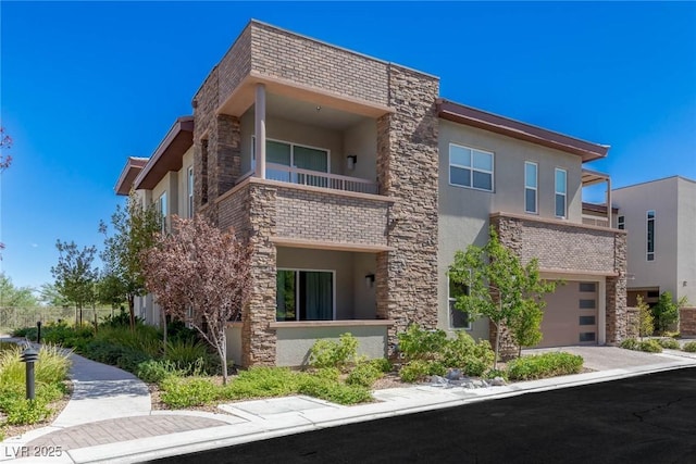 11280 Granite Ridge Dr Unit 1009, Las Vegas, NV 89135 - view of front of home with stucco siding, a balcony, an attached garage, and stone siding