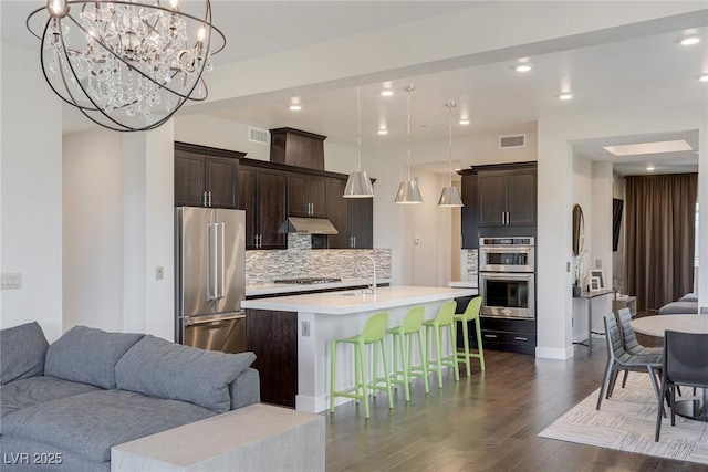 11280 Granite Ridge Dr Unit 1009, Las Vegas, NV 89135 - kitchen with stainless steel appliances, open floor plan, light countertops, under cabinet range hood, and tasteful backsplash